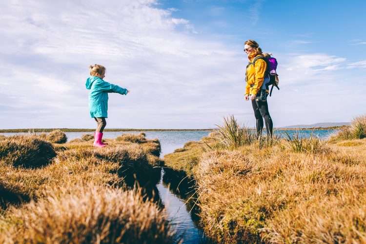 mother and daughter standing on cliffs