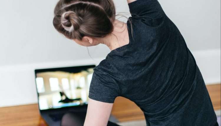 woman in black t-shirt and black pants lying on black yoga mat