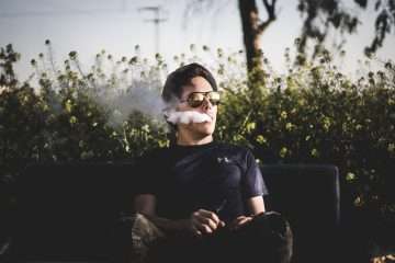 man sitting on bench and smoking