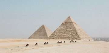 people travelling towards two pyramids