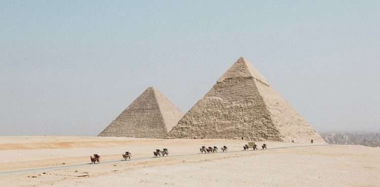 people travelling towards two pyramids