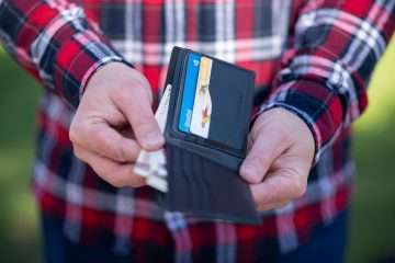 person holding black leather bifold wallet