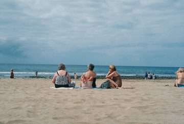 three women sitting on beach