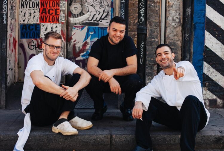 Three Men Sitting on Street Curb