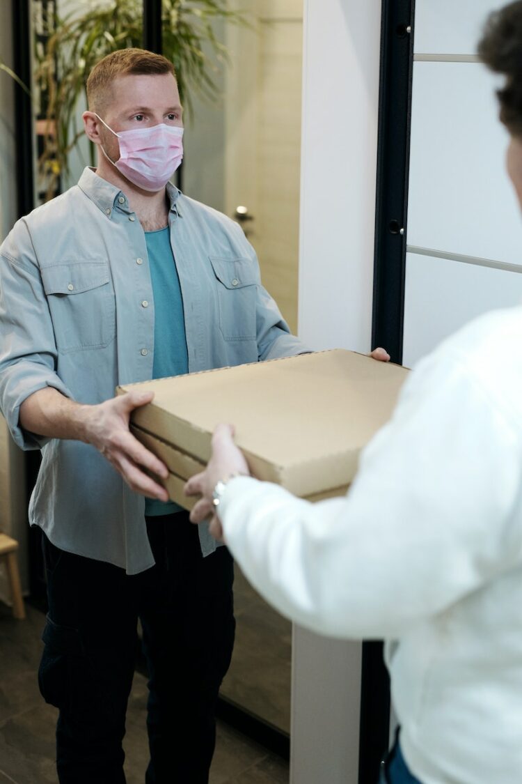 Man Wearing a Face Mask Receiving a Pizza Delivery