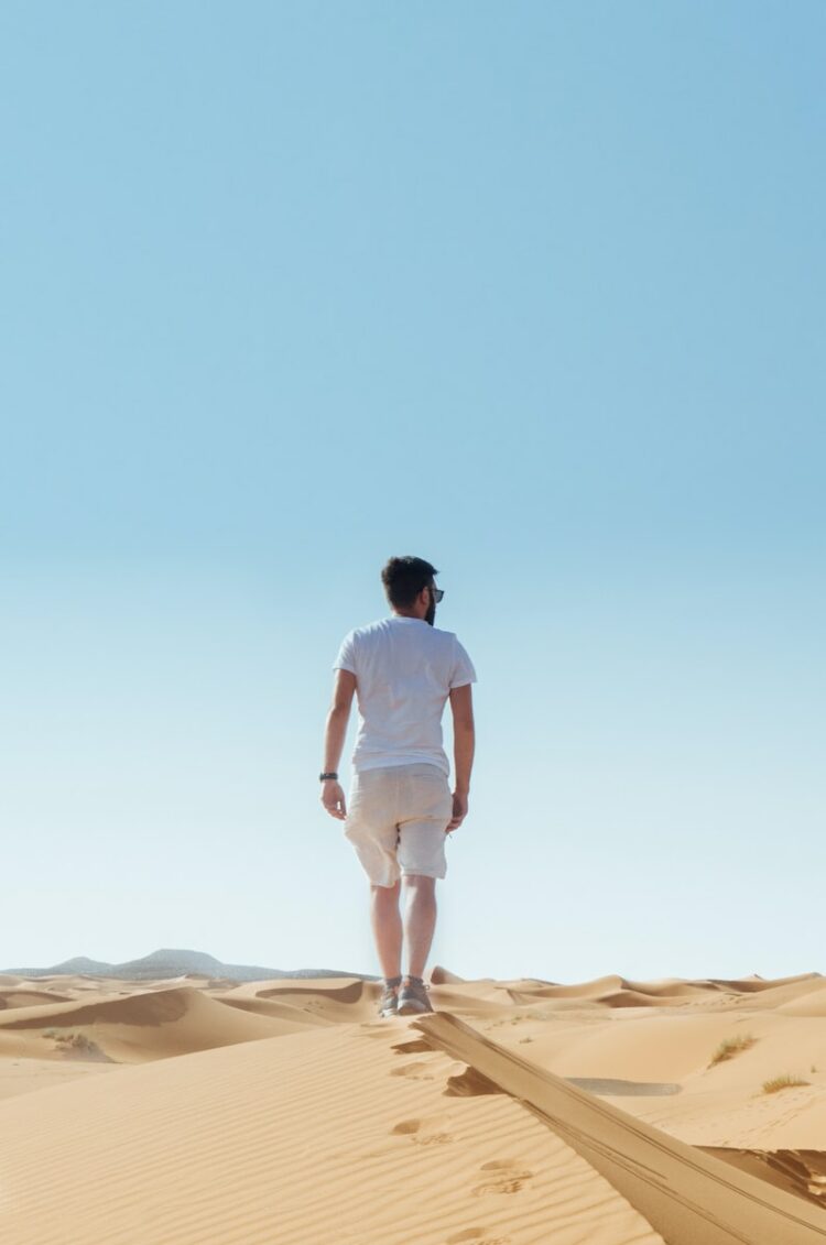 man standing on sand field