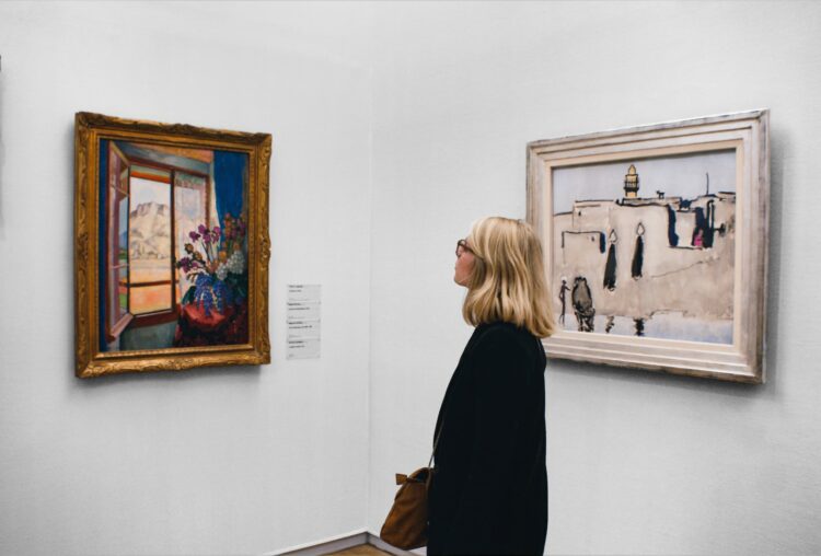 woman looking at painting in museum
