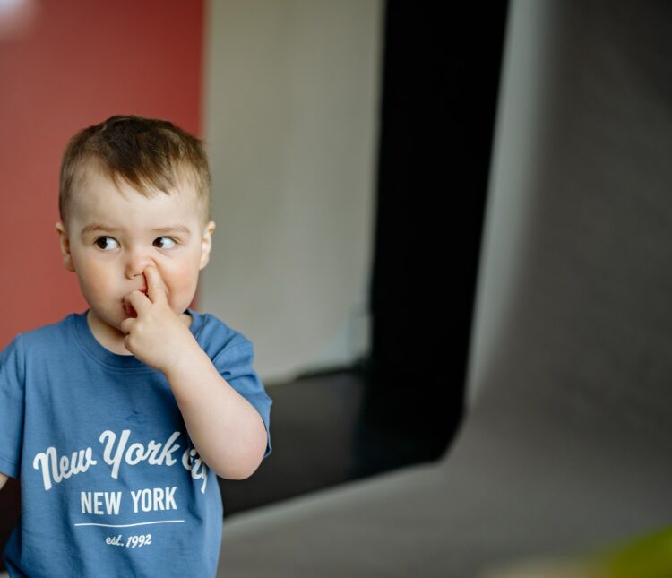 Boy in a Blue Shirt Doing the Bad Habit of Picking His Nose