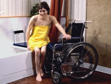 a disabled woman in a yellow towel sitting in a wheelchair