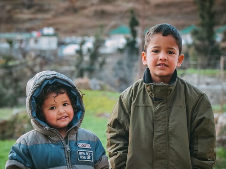 man in gray jacket beside boy in gray jacket